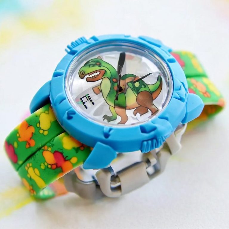 Bunte Kinderuhr mit Dinosaurier-Motiv und grünem, gemustertem Armband.