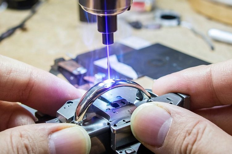 Jemand arbeitet sorgfältig an einem Ring mit einem Laserwerkzeug.