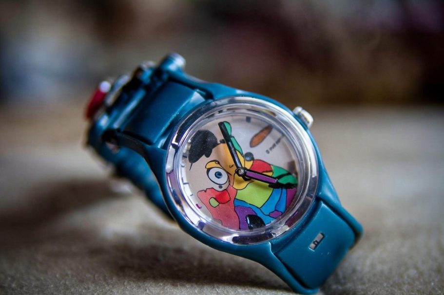 Bunte Armbanduhr mit Cartoon-Motiv und blauem Armband.