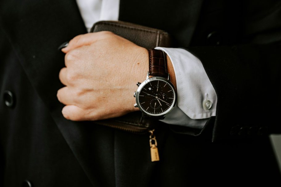 Händedetail in Anzug mit Uhr und Geldbörse, elegant und stilvoll.